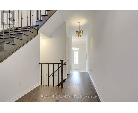 A hallway with a staircase and a chandelier.