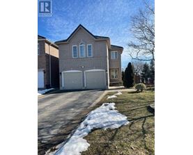 A house with a garage and a driveway in front of it.