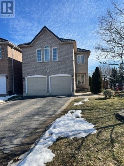 A house with a garage and a driveway in front of it.