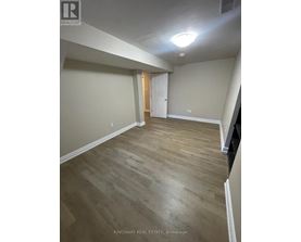 A room with wooden flooring and a white door.