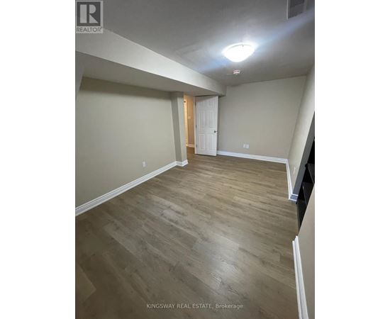 A room with wooden flooring and a white door.