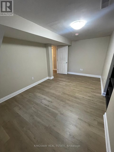 A room with wooden flooring and a white door.