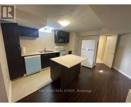 A kitchen with a white countertop and black cabinets.