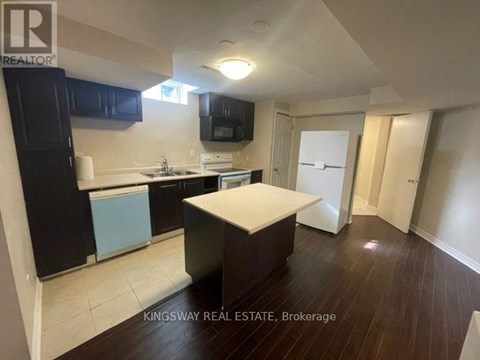 A kitchen with a white countertop and black cabinets.