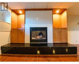 A modern living room with a fireplace and wooden cabinets.