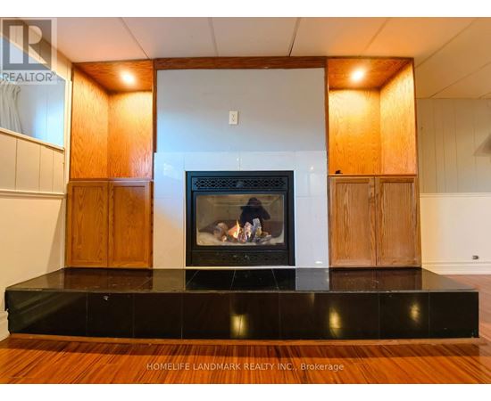 A modern living room with a fireplace and wooden cabinets.