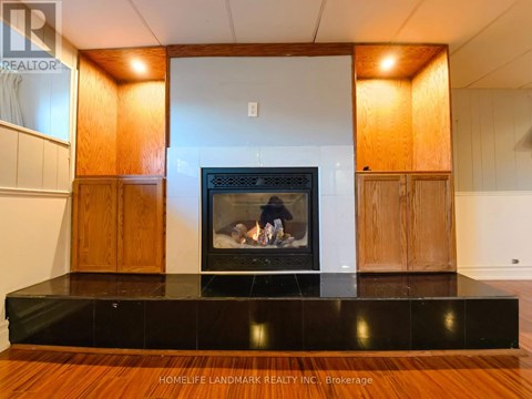 A modern living room with a fireplace and wooden cabinets.