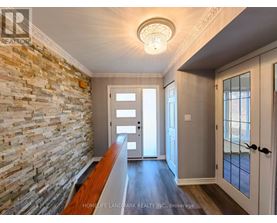 A hallway with a stone wall and wooden floor.