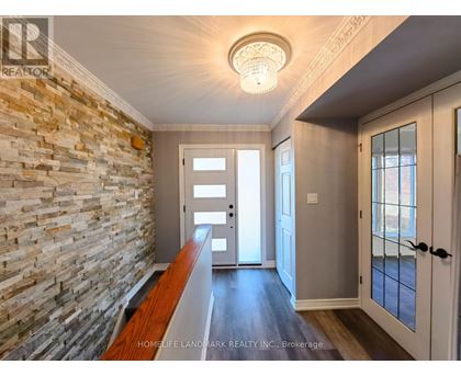 A hallway with a stone wall and wooden floor.