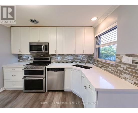 A kitchen with white cabinets and a stone backsplash.
