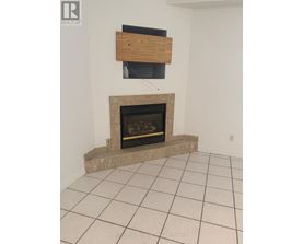 A fireplace with a wooden mantle and a black screen above it.