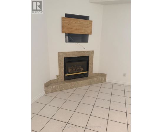 A fireplace with a wooden mantle and a black screen above it.