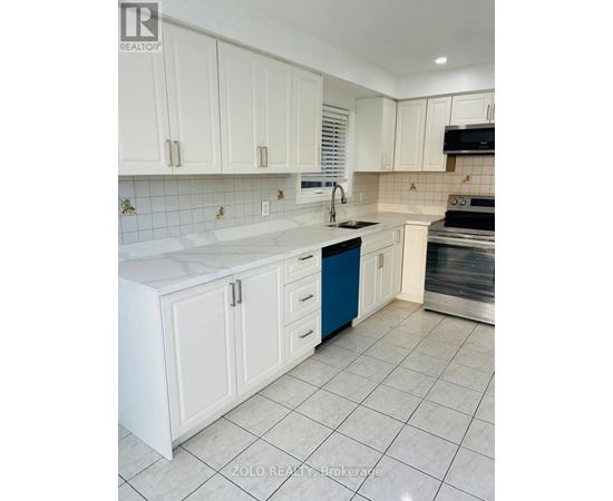 A kitchen with white cabinets and a blue drawer.