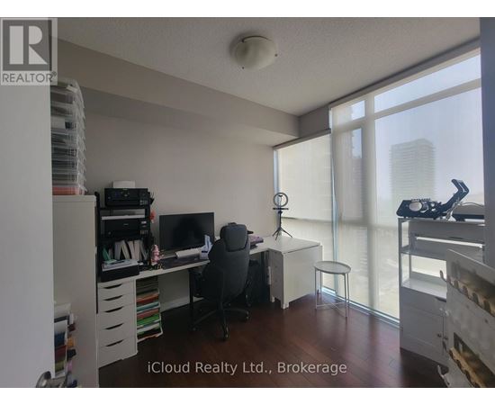 A room with a desk, a chair, and a window overlooking a cityscape.