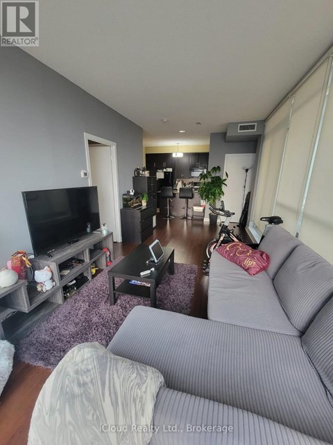 A living room with a grey couch and a television.