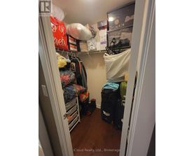 A small closet with a lot of clothes and bags.