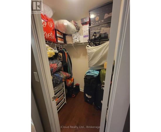 A small closet with a lot of clothes and bags.