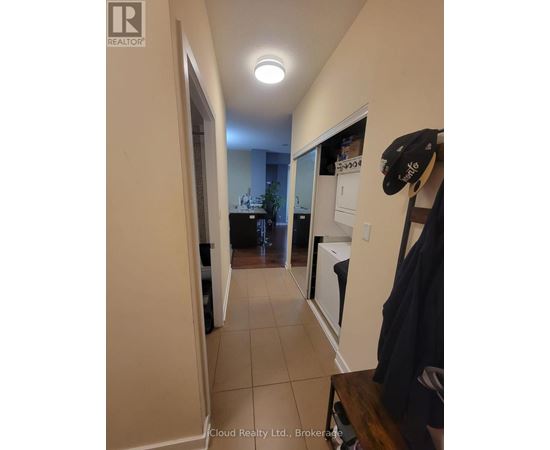 A hallway with a coat rack and a sign that says "Cloud Realty Ltd., Brokerage.".