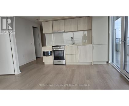 A kitchen with white appliances and wooden cabinets.