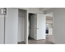 A white door is open in a white room.