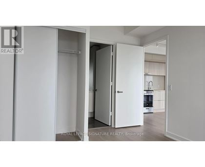 A white door is open in a white room.