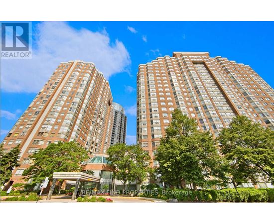 Two large apartment buildings with trees in front.
