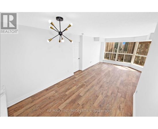A room with wooden flooring and a ceiling fan.