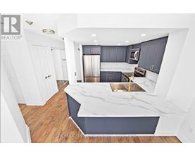 A modern kitchen with a marble countertop and stainless steel appliances.