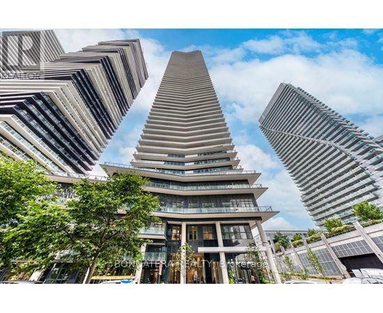 A tall building with a unique triangular top is surrounded by other buildings.