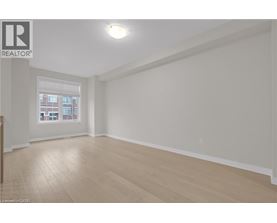 A spacious room with wooden flooring and a window.