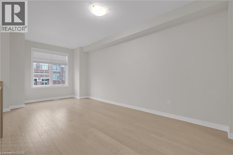 A spacious room with wooden flooring and a window.