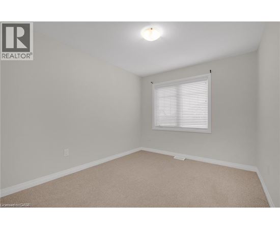 A room with a window and carpeted floor.