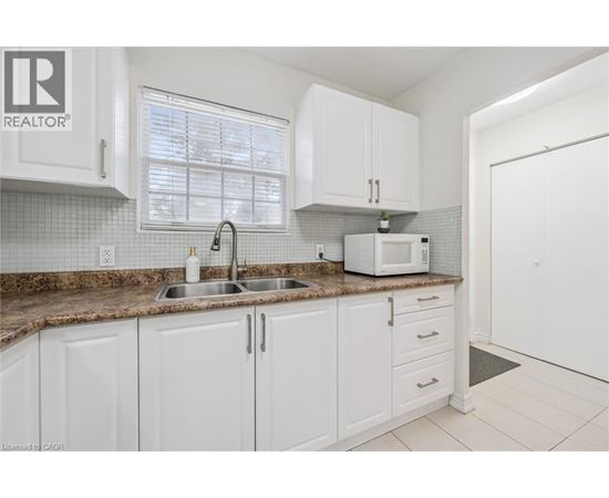 A kitchen with white cabinets and a brown countertop.