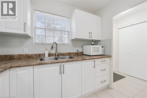 A kitchen with white cabinets and a brown countertop.