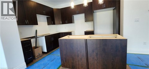 A kitchen with dark wood cabinets and a white counter top.