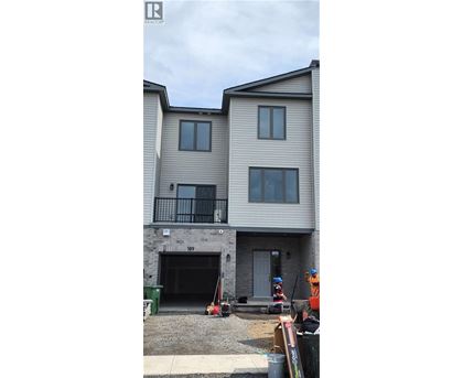 A two-story residential building with a garage door and a balcony.