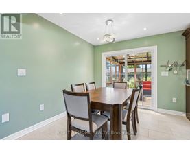 A dining room with a table and chairs.