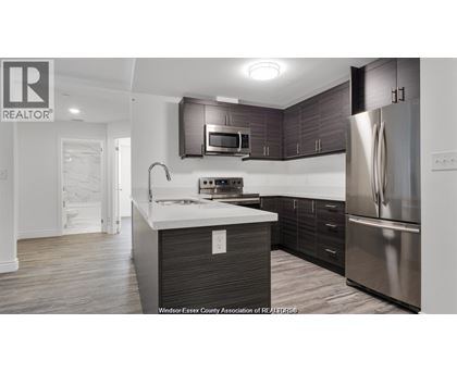 A modern kitchen with dark wood cabinets and stainless steel appliances.