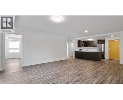 A spacious living room with a kitchenette in the background.