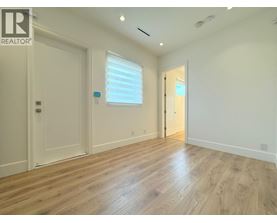 A room with wooden flooring and white walls.