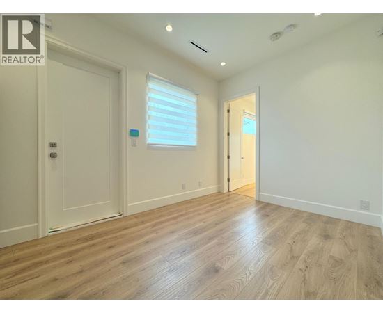 A room with wooden flooring and white walls.