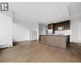 A spacious, empty room with wooden floors and white walls.