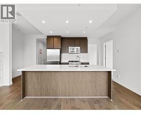 A modern kitchen with a large island and wooden cabinets.