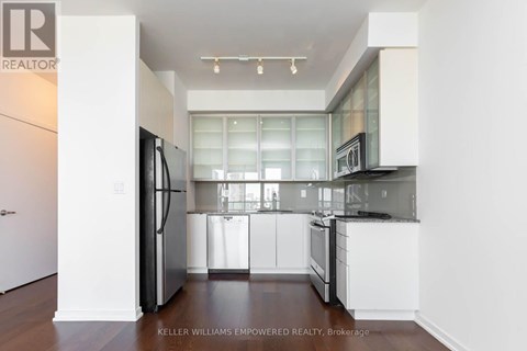 A modern kitchen with white cabinets and a glass window.