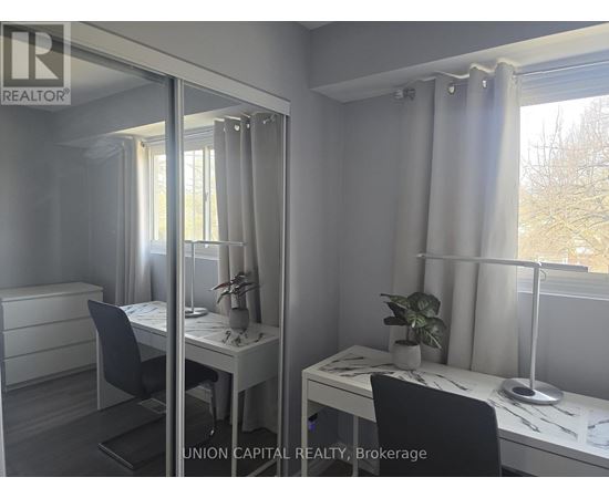 A room with a desk, chair, and mirror.