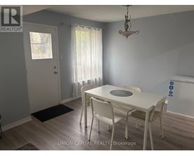 A dining room with a white table and chairs.