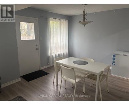 A dining room with a white table and chairs.