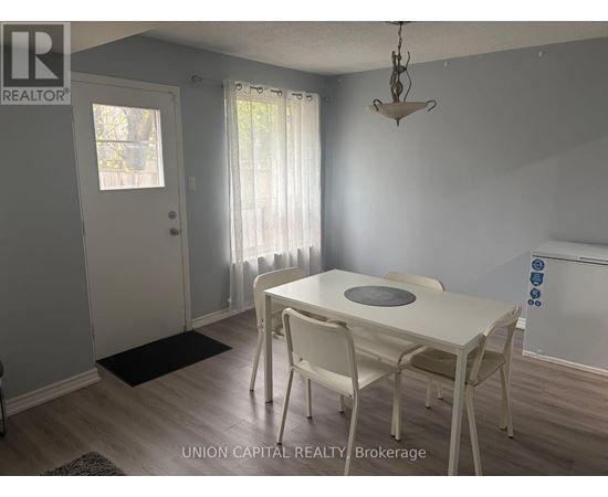 A dining room with a white table and chairs.
