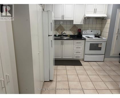 A kitchen with white cabinets and appliances.