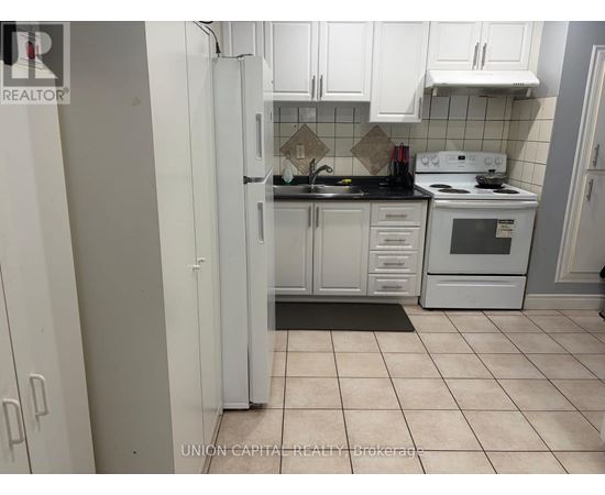 A kitchen with white cabinets and appliances.